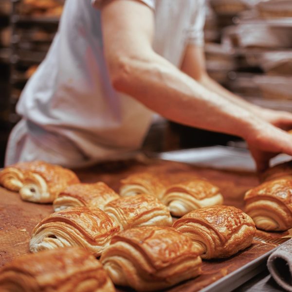 cook-arranging-the-freshly-baked-croissants-on-a-t-2023-11-27-04-52-46-utc_11zon_11zon.jpg